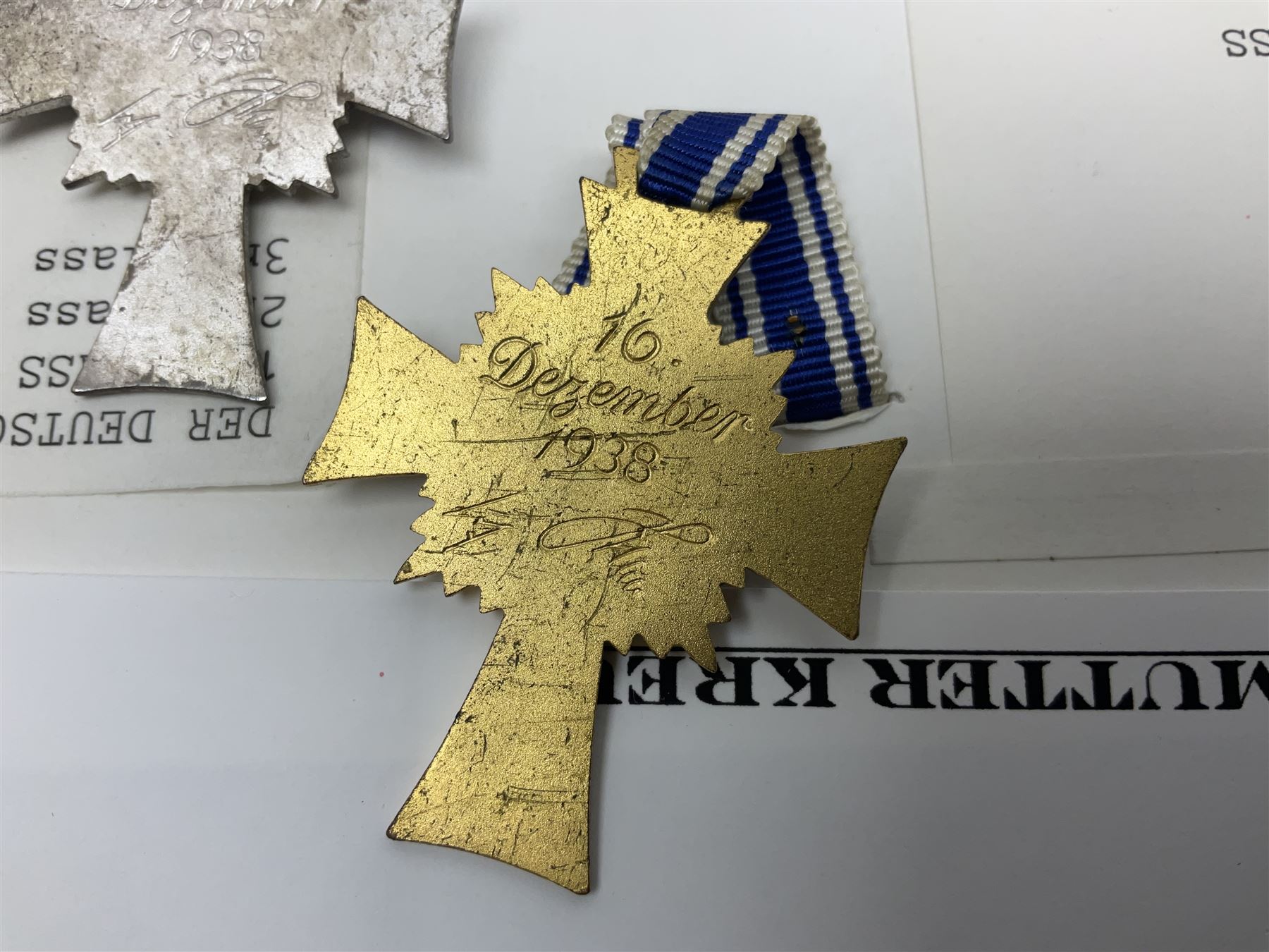 WWII set of three German Mother's Crosses, 1st Class in gilt, 2nd Class in silver and 3rd Class in bronze; all with ribbons (3)