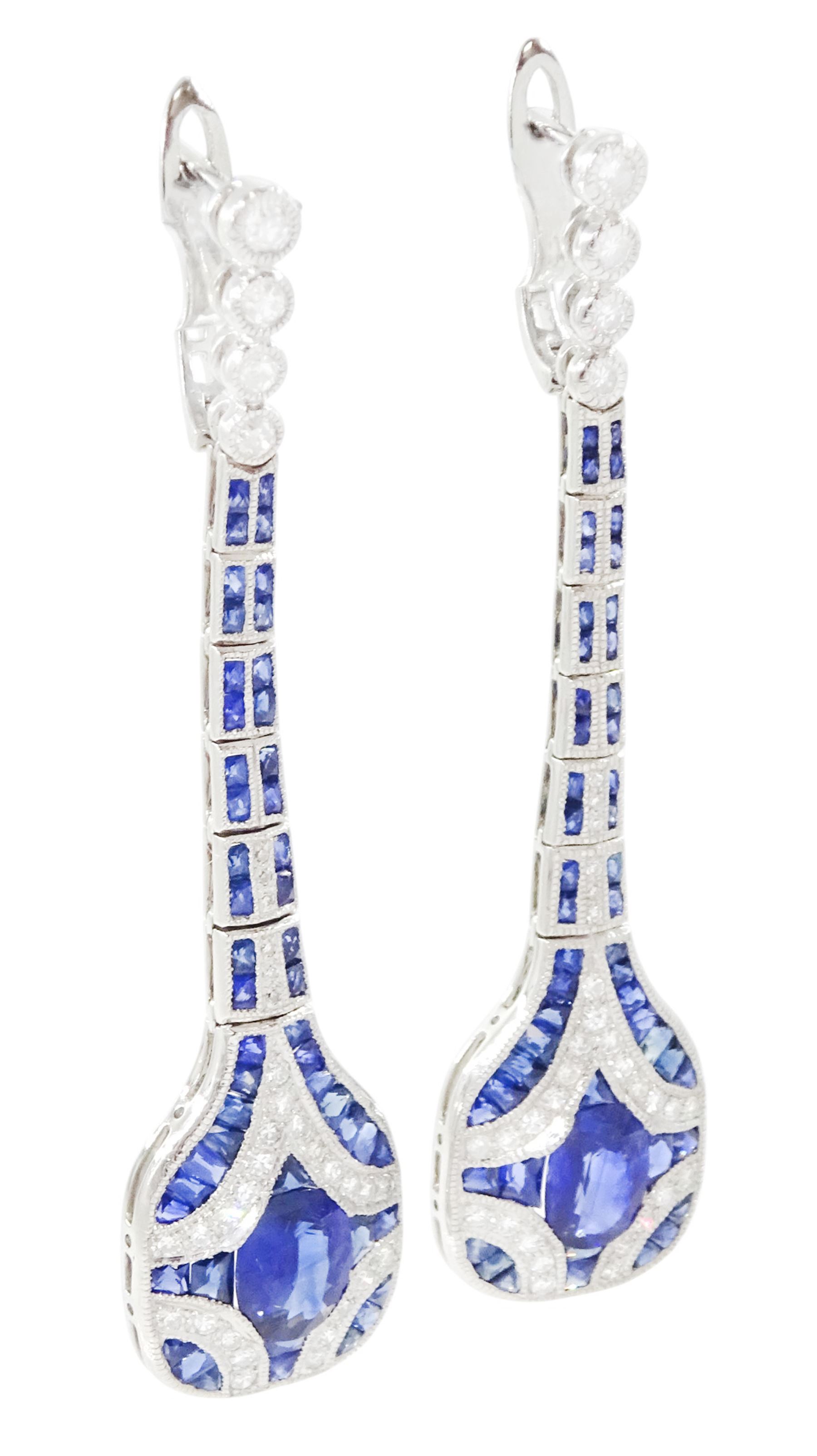 Pair of platinum sapphire and diamond pendant earrings, each stud milgrain set with a single oval cut sapphire, surrounded by calibre cut sapphires and single cut diamonds, suspending from six graduating articulated panels, to four single cut diamonds, total sapphire weight approx 3.80 carat, total diamond weight approx 0.80 carat