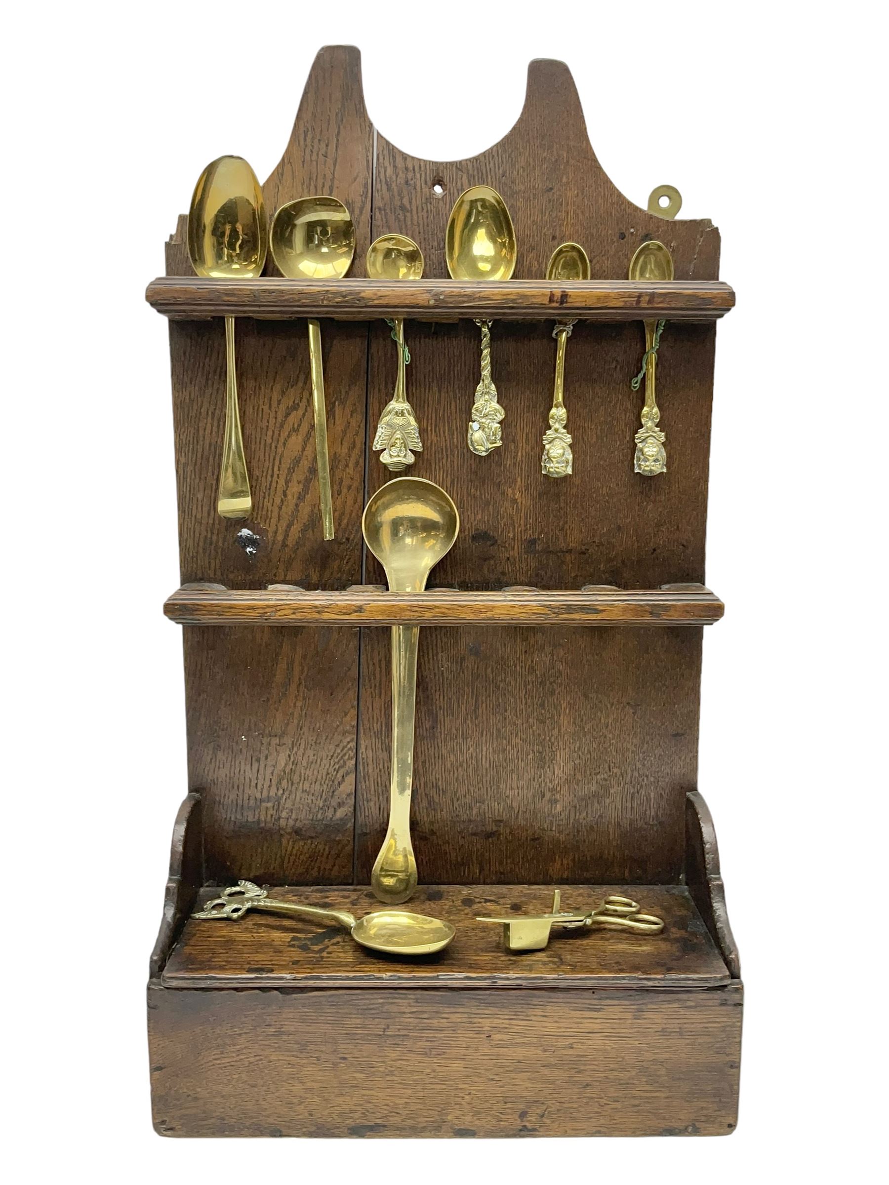 George III oak spoon rack and candle box, the rectangular backplate with shaped  pediment and two six aperture spoon racks, above a candlebox with hinged cover, with various brass spoons and a pair of brass candle snuffers, H56.5cm, W35cm, D14cm 