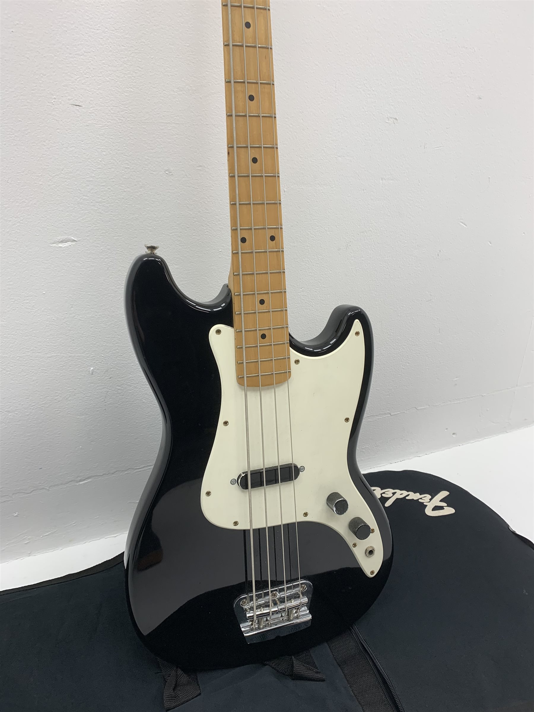  Fender Squier Bronco Affinity Series electric bass guitar, in black and white, serial no. IC021107489, L108cm, in associated Squier soft carrying case. From the collection of the late John Burgess of Beverley who played in the bands Penjants, Wine, Strollers, Revox, Sound Foundation, Pickle Belly Alley, Ragamuffins and Jerryattricks.