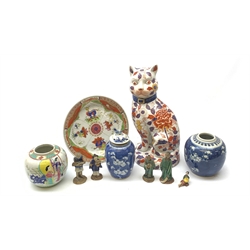 A group of Oriental ceramics, comprising two blue and white prunus pattern ginger jars, each with double blue concentric band marks beneath, (one lacking cover, the other with associated cover with fo dog finial), a 20th century Oriental figure modelled as a cat, decorated in Imari pallet, with character marks beneath, H33cm, a further ginger jar, and plate (both a/f). 