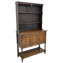 Early to mid-20th century oak dresser, raised two tier plate tack over two linenfold panelled doors, on spiral turned supports united by undertier 