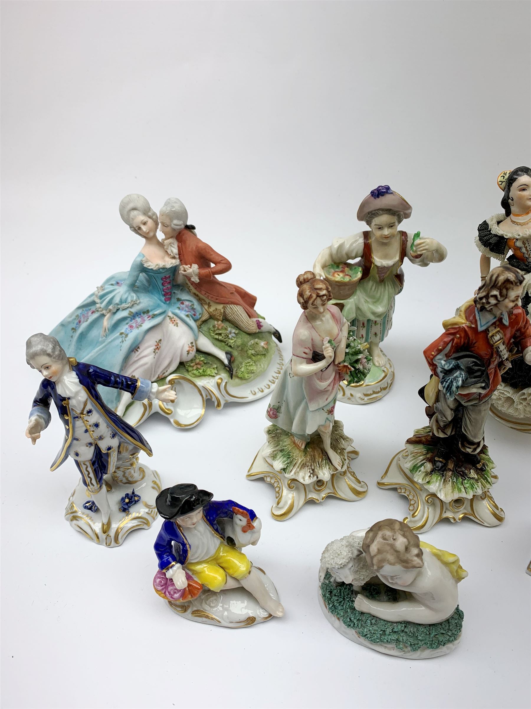 A group of various Continental figures, to include examples marked Dresden and Capodimonte, plus others with spurious blue cross marks beneath. (14). 