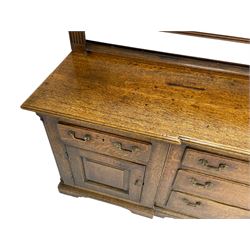 George III oak dresser, projecting dentil cornice over three heights plate rack enclosed by fluted uprights, the dresser fitted with five drawers and two panelled cupboards, canted corners with fluted quarter columns, on bracket feet