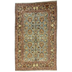 Central Persian Qum pale blue ground rug, the field decorated with stylised plant motifs surrounded by trailing foliate vine patterns in a symmetrical format, the multi-band guarded indigo border decorated with repeating flowerheads 