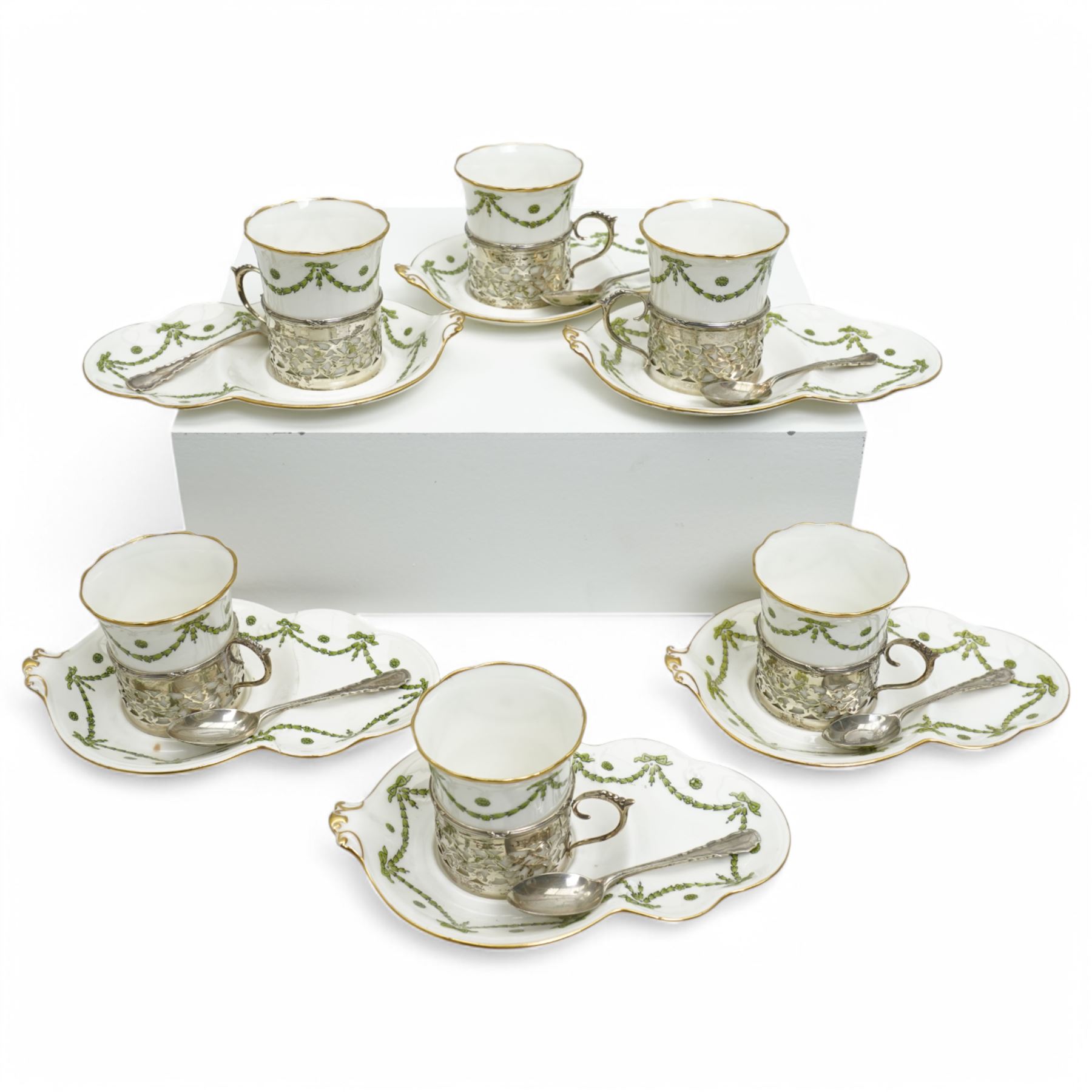 Set of Six Aynsley coffee cans and saucers decorated with garlands, the cans held in pierced silver holders Birmingham 1912 Maker Charles Green & Co and six silver spoons London 1939 Maker Josiah Williams & Co