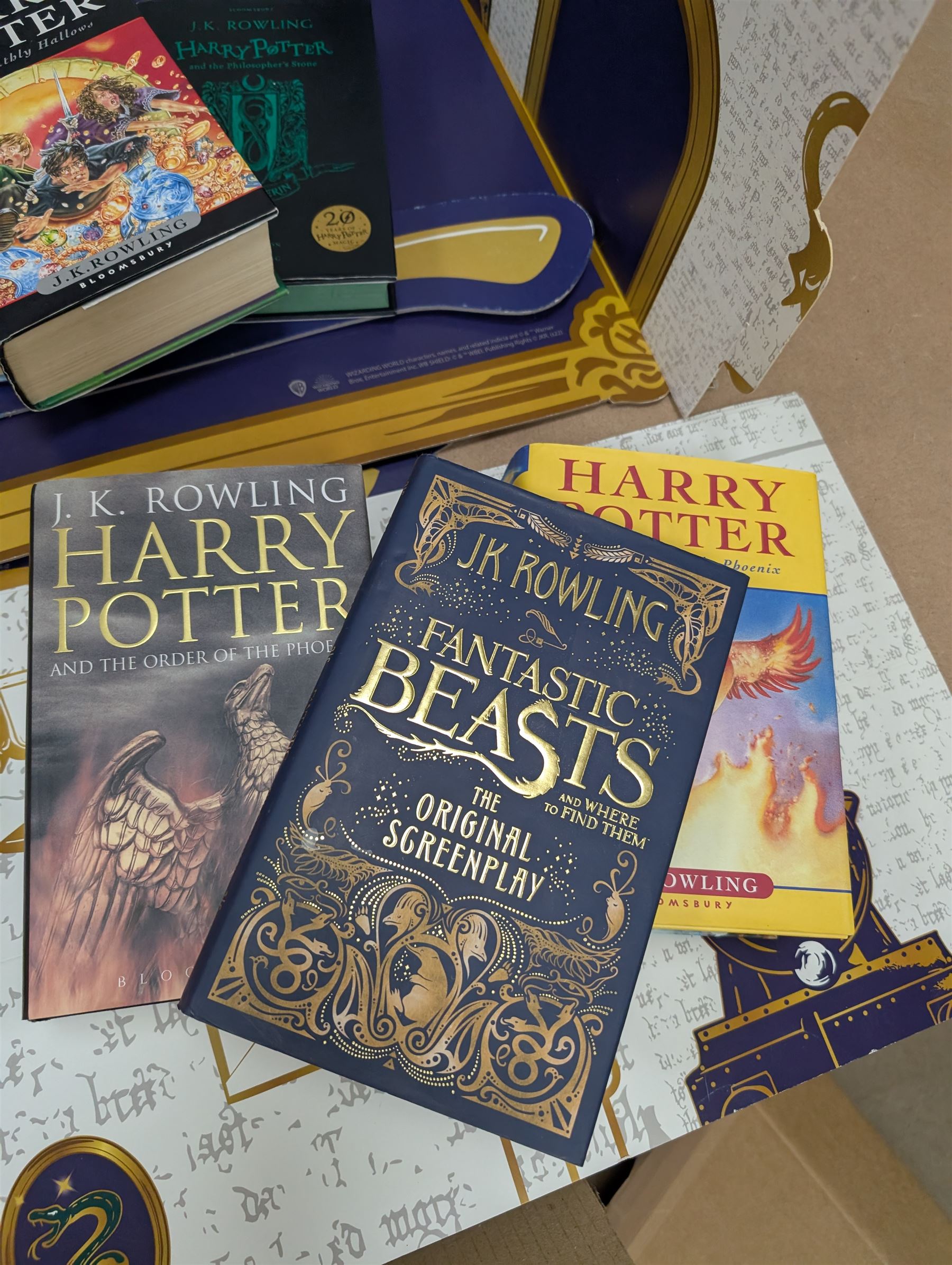 Eleven JK Rowling books, comprising six Harry Potter books, including four first editions, Fantastic Beasts screen play, Harry Potter and the Cursed Child, Tales of Beedle the Bard, Casual Vacancy first edition, Christmas Pig First edition and a Harry Potter card board back drop