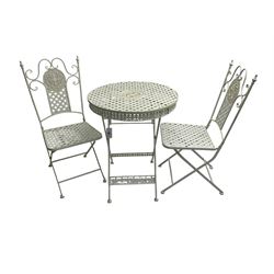 Victorian design white painted wrought metal folding garden table, circular top with pierced central medallion and ornate lattice design, with fleur-de-lis frieze (W65cm H76cm); and a pair of matching chairs, scroll design back with pierced rosette (W40cm H95cm)