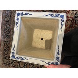 Chinese blue and white planter and stand, each of square slightly tapering and flared form, the planter decorated with two dragons and blossoming peonies, between stylised borders, the stand decorated with flower heads and vines, planter H30cm W29cm, stand H7cm D28.5cm