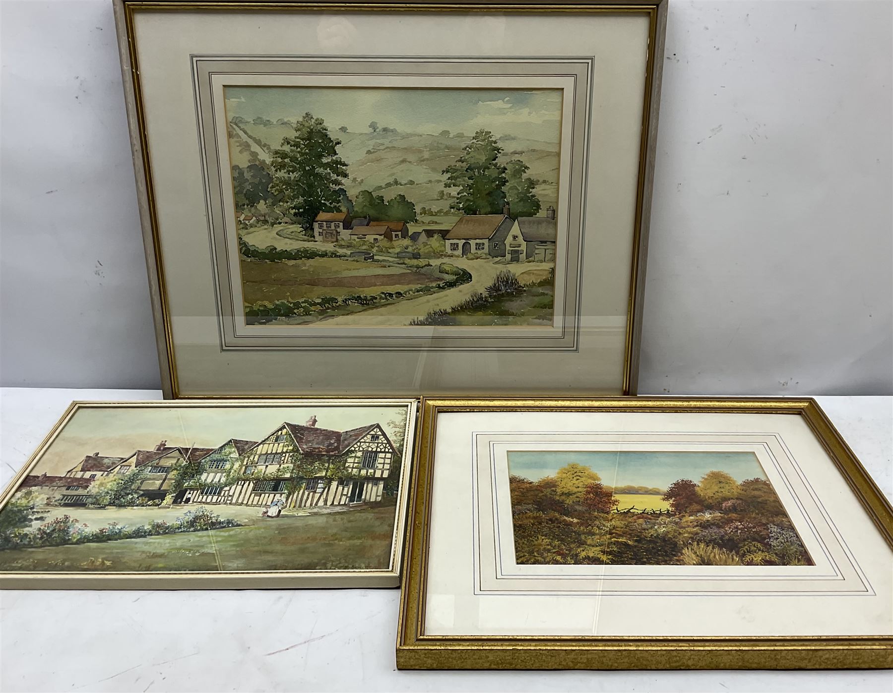 George Hewitt (British 19th/20th century): Manor House Landscape, watercolour signed and dated 1894, 26cm x 36cm; English School (20th century): Autumn Field Landscape, gouache indistinctly signed 17cm x 25cm; English School (20th century): Dales Hamlet Landscape, watercolour indistinctly signed 25cm x 33cm (3)