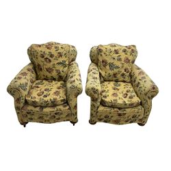 Pair late 19th century armchairs, upholstered in pale yellow floral pattern fabric, on compressed bun feet with castors