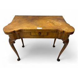 Georgian walnut fold-over card table, shaped rectangular top opening to reveal a baize-lined surface, supported by a concertina pull-out rear mechanism, frieze fitted with single drawer, raised on cabriole supports with foliate carvings terminating in pad feet