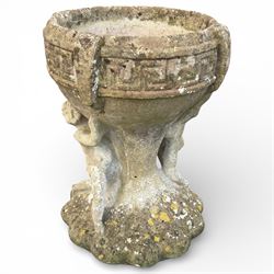 Cast stone urn with two figures supporting the bowl