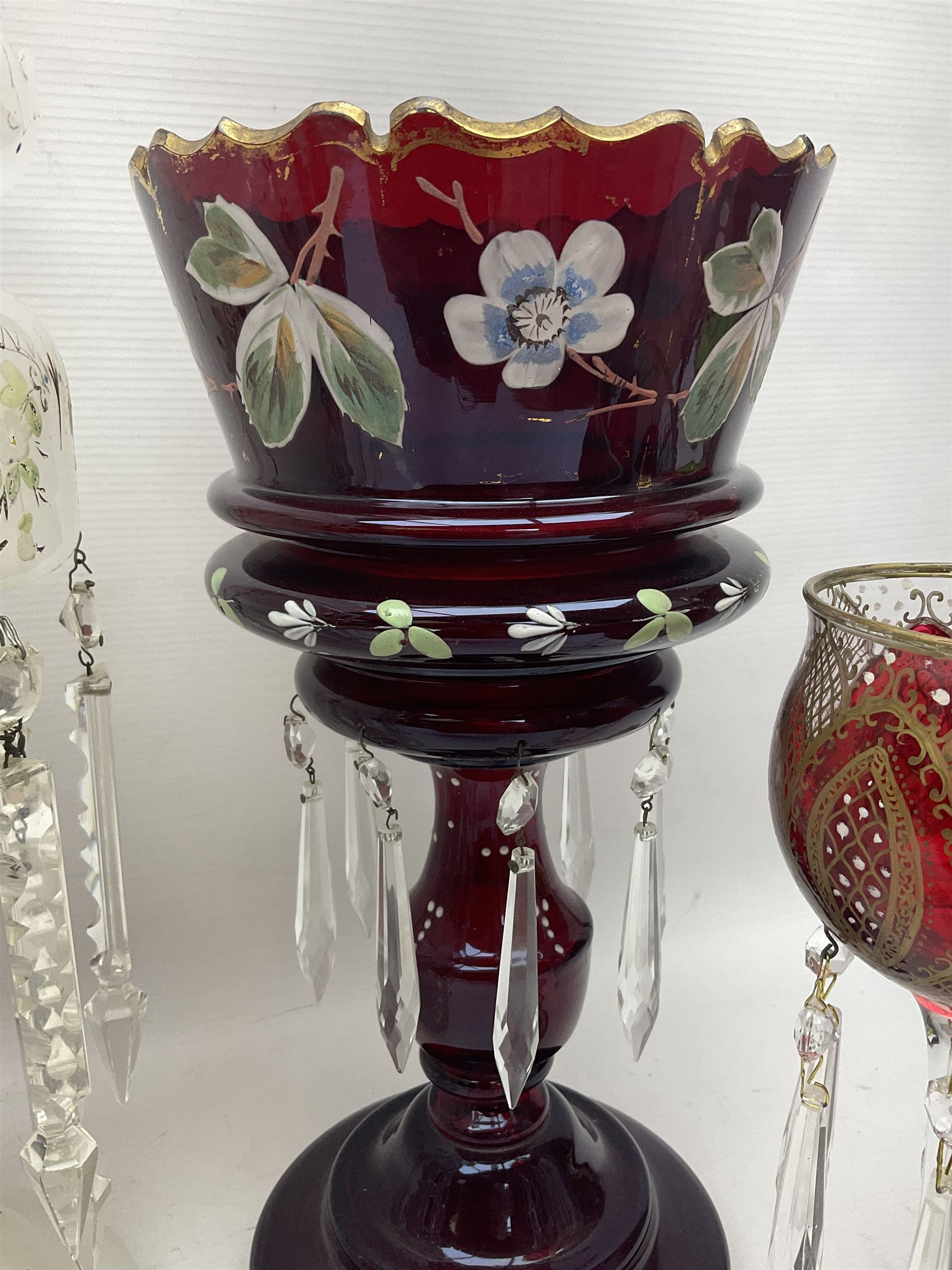 Bohemian red glass lustre, painted with stylised floral and foliate decoration, together with a milk glass example and two bohemian goblets converted to lustres 