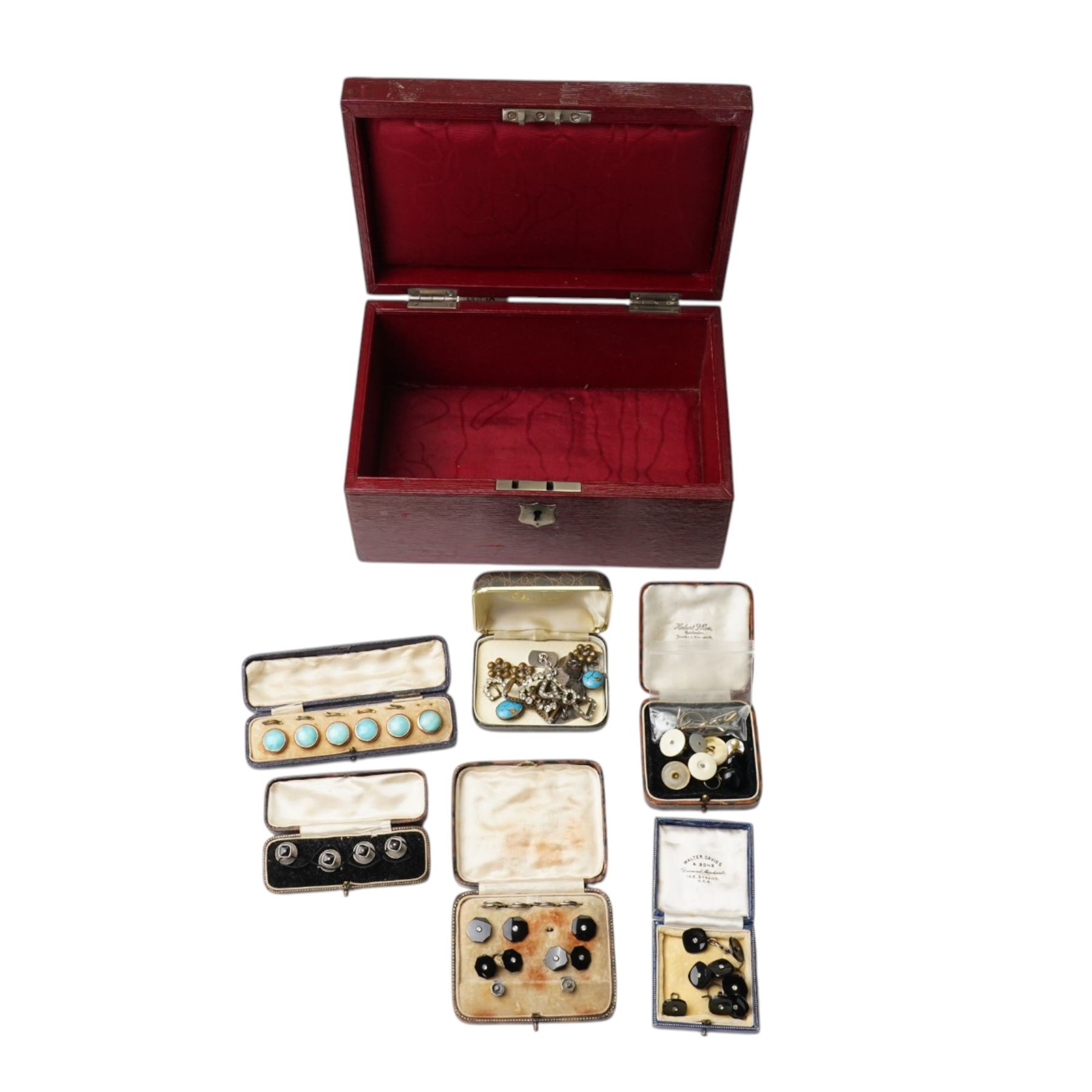 Early 20th century dress sets including onyx and paste examples, some stamped 935, paste set buckles and buttons, faux turquoise jabot pin, in the style of Bernard Instone, silver cufflinks etc, housed in an early 20th century red leather jewellery box