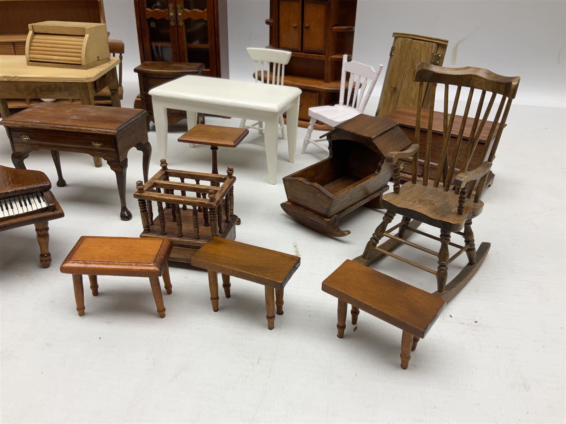 Doll's house wooden furniture - over twenty items including good quality pine Welsh dresser by Tony of Lincoln; tall 'glazed' bookcase; two-tier side cabinet; grand piano; bedside chest, mule chest, Canterbury; cradle; Georgian style hanging corner cupboard; dumb waiter; tables; chairs; rocking chair etc; various scales
