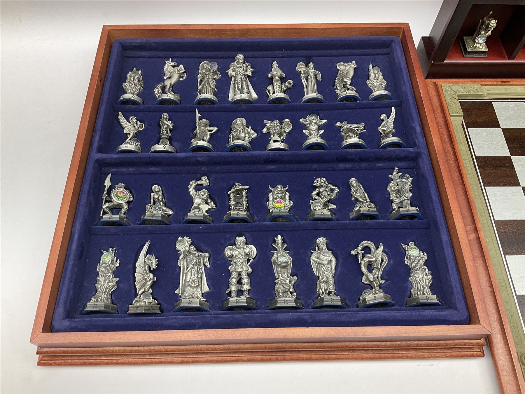 Danbury Mint 'The Fantasy of the Crystal' chess set consisting of mythical pewter chess pieces within a wooden case with chess board lid, together with 16 additional chess pieces in a wooden display case.