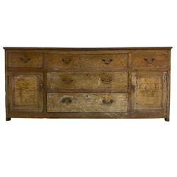 George III stripped oak dresser base or sideboard, fitted with three graduating central drawers, flanked by two drawers and panelled cupboards, on stile supports