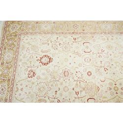 Modern Pakistani Oushak style wool hand-knotted carpet,  ivory field with an all-over scrolling floral vine design in soft tones of madder red and pale gold, enclosed by a conforming border, with cotton fringe ends  