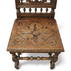 18th century carved oak hall chair, the rectangular pierced back carved with scrolling foliate ornament and central rosette beneath a shaped cresting, the boarded seat carved with stylised foliage, raised on turned legs united by stretchers