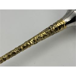 Pair of modern silver candlesticks by Stuart Devlin, the tapering parcel gilt stems with signature textured detailing, each supporting a fluted candle holder and upon a spreading circular foot, hallmarked Stuart Devlin, London 1973, H25cm