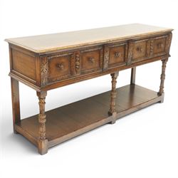 Titchmarsh & Goodwin - Tudor oak dresser base, three drawers flanked by foliate carving and carved wooden knobs, on turned and carved supports, united by a full length undertier