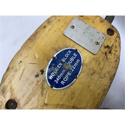 Three ship pulleys comprising wooden block double with swivel eye marked 'wooden block 240mm double rope: 22mm',  wooden block double with upset shackle and wooden block with stiff swivel hook, largest example L50cm
