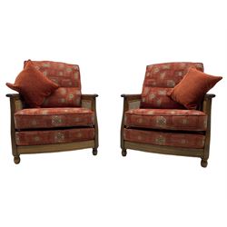 Ercol medium elm framed three seat bergere sofa, and pair of matching armchairs upholstered in red fabric