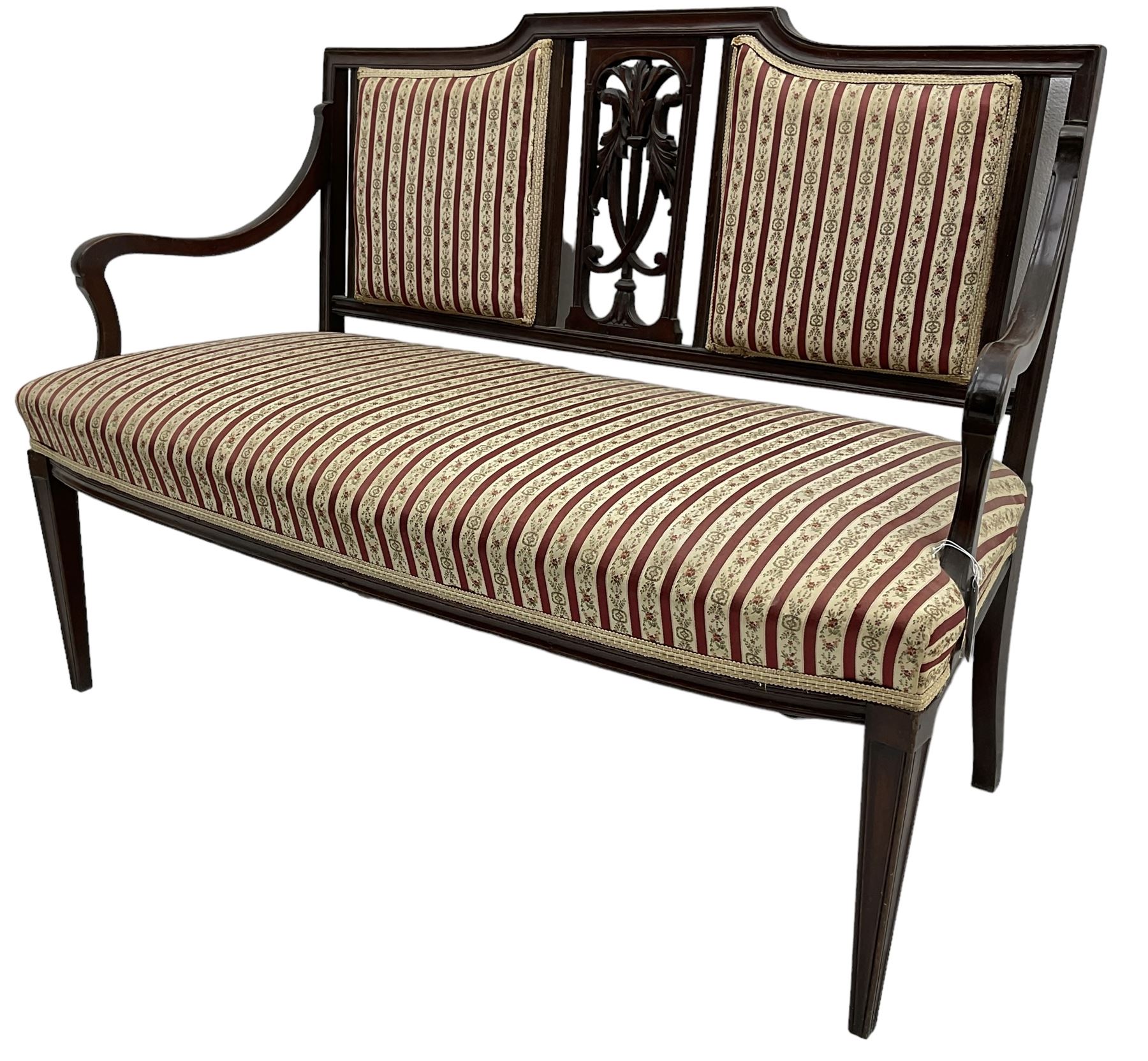 Edwardian mahogany framed three-piece salon suite - two-seat sofa, stepped cresting rail over acanthus and scroll carved pierced splat, upholstered in striped fabric (W124cm, H87cm, D62cm); and a pair of matching armchairs (W60cm) 