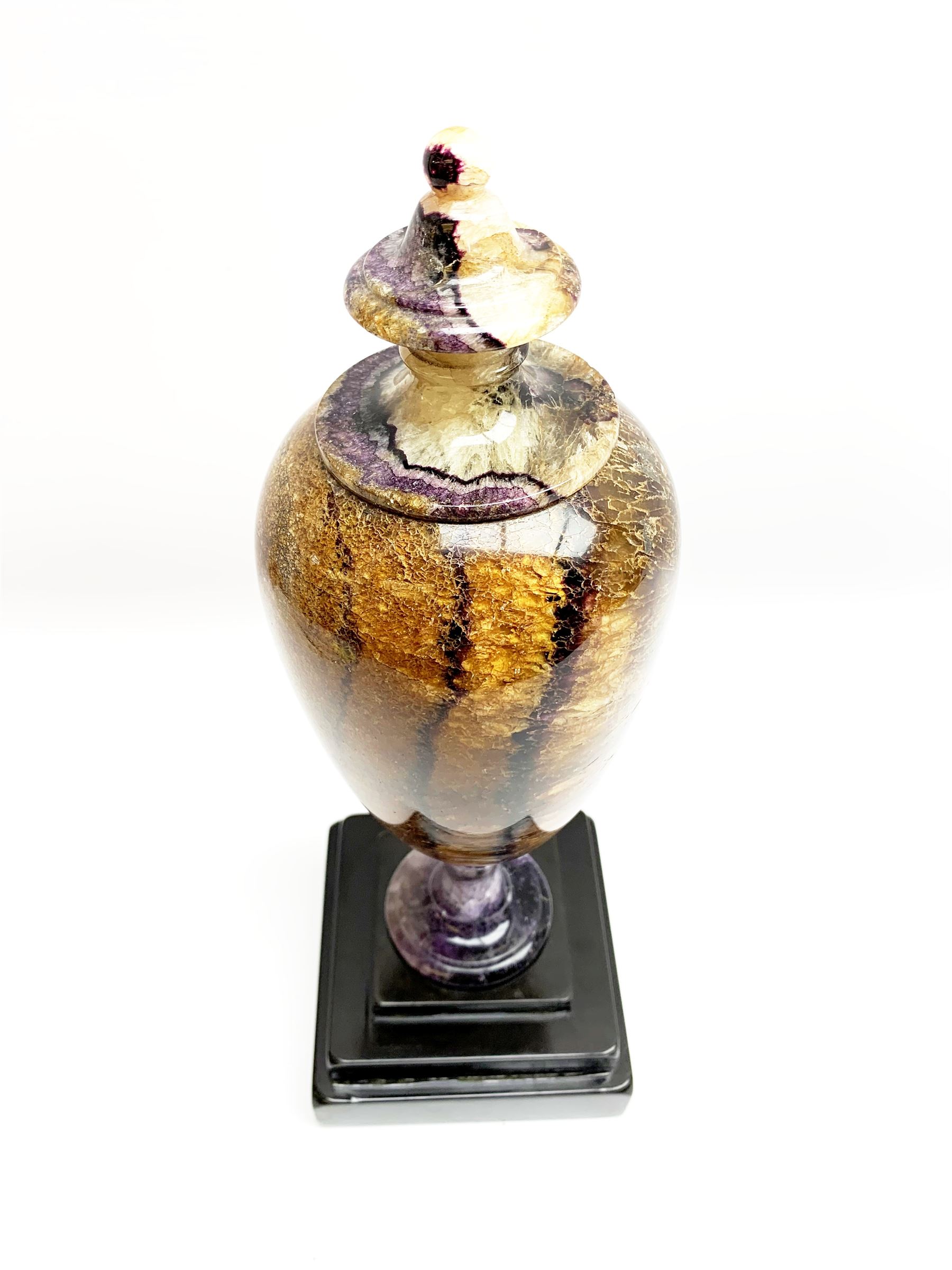 Early 19th century and later Blue John urn, Winnats one vein, of ovoid form with integrated cover and ball finial, upon a spreading circular base, and square stepped black lacquered base, H34.5cm