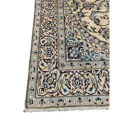 Persian Kashan ivory ground rug, central medallion surrounded by scrolling leafy branches and stylised flowerhead motifs, scrolling border decorated with further stylised plant motifs