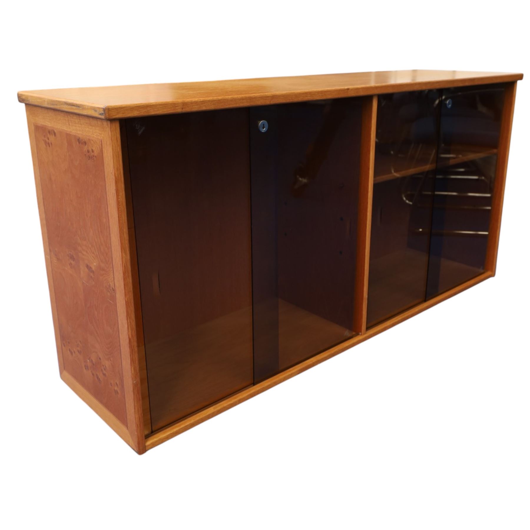 Light oak bookcase cabinet, fitted with four sliding tinted glass doors