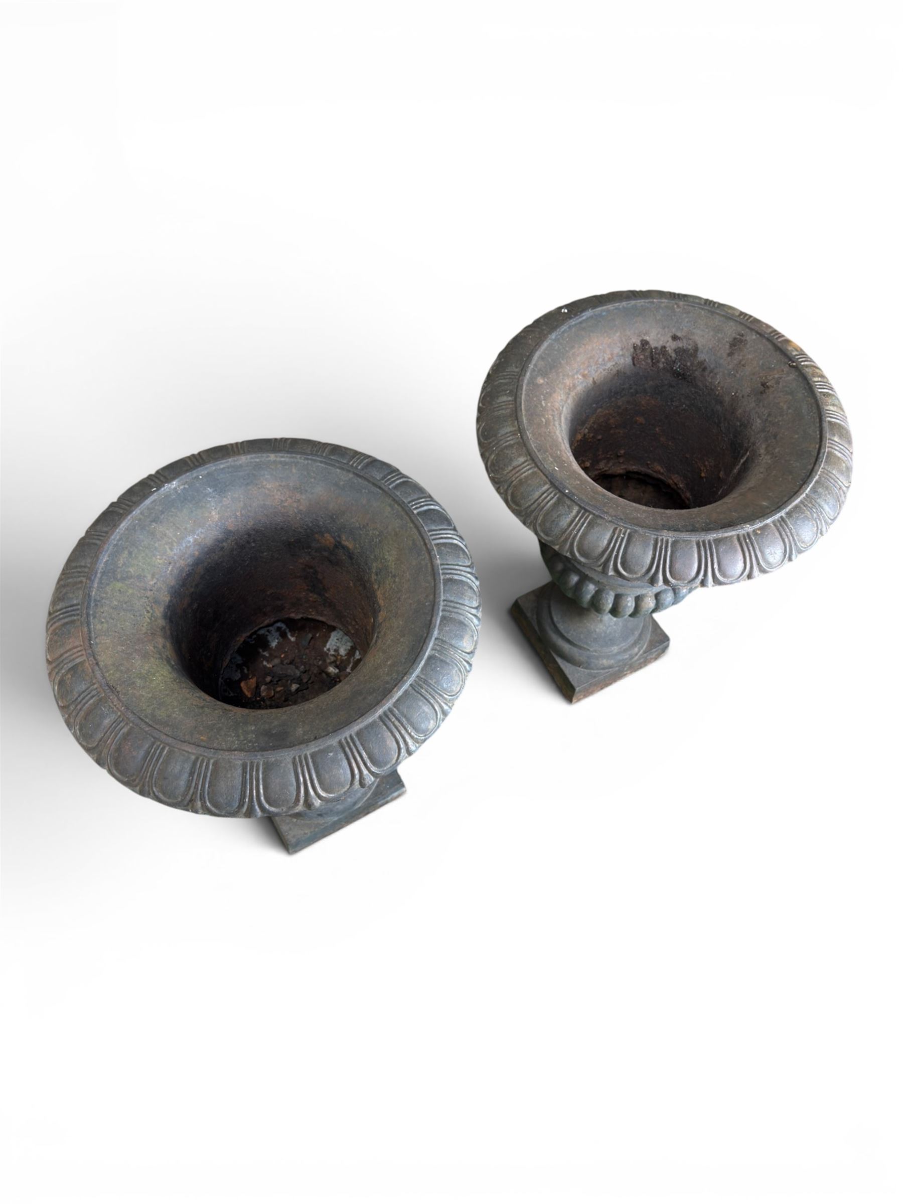 Pair of Victorian design heavy cast iron garden urns, black painted, egg and dart rim on waisted column