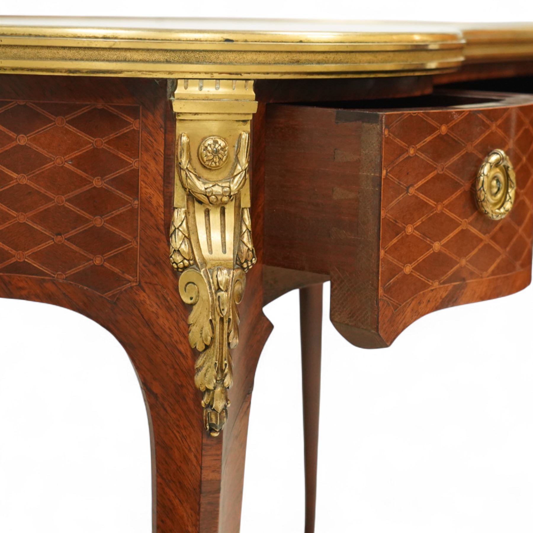 Late 19th-century Louis XV-style marquetry and gilt bronze-mounted kidney-shaped writing table, of serpentine form, top finely veneered with a trellis parquetry pattern, within a gilt bronze moulded edge, above a shaped frieze fitted with a central drawer flanked by two short drawers, similarly inlaid side and legs, knees with gilt bronze foliate mounts and cabriole legs terminating in gilt bronze sabots
