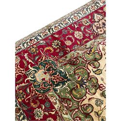 Persian Tabriz ivory ground carpet, the field with all over interlaced foliate decoration and central medallion, floral design border set with a series of stylised flower cartouche medallions