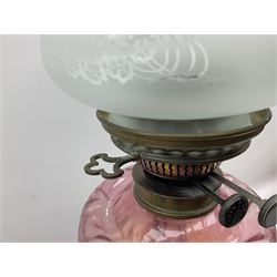 Victorian table oil lamp with black glazed stepped circular base, reeded brass column, moulded pink glass reservoir, duplex burner and frilled rim frosted glass shade with clear glass chimney H69cm