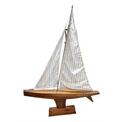 Large pond yacht with simulated planked mahogany deck, mahogany hull, wooden keel and stern fin and tubular aluminium mast with two sails; on wooden stand L131cm H on stand 177cm