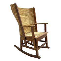 Reynold Eunson (1932–1978) for David Munro Kirkness, Kirkwall, Orkney - oak framed Orkney rocking chair, woven straw curved back, drop-in rush seat, the arm terminals with carved end scroll, on square tapering supports joined by plain stretchers, the front rail inscribed with makers marks
