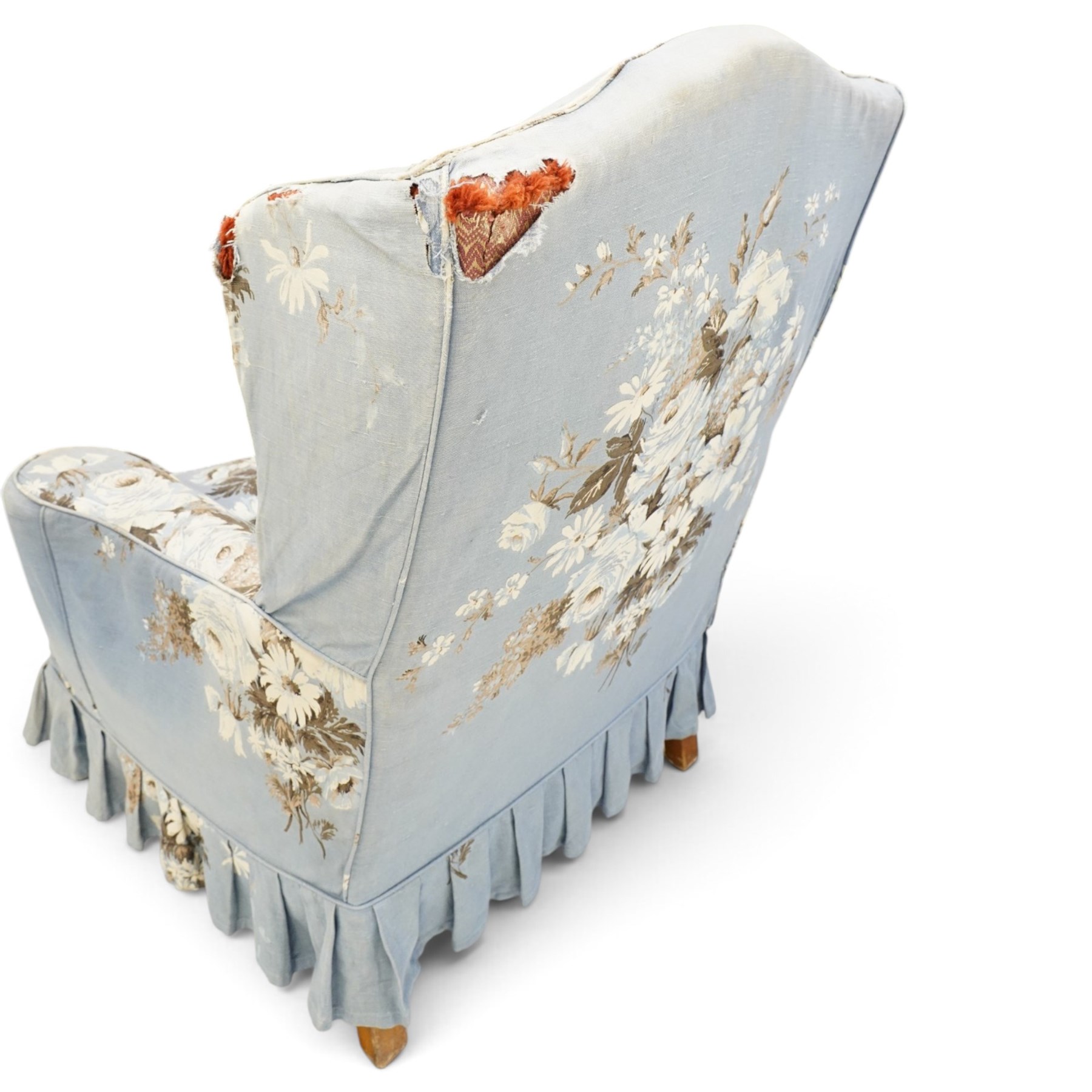 Pair of Queen Anne wingback armchairs, high back over out-swept arms, raised on ball-and-claw feet, upholstered in sky-blue ground floral chintz loose upholstery with pleated skirt and squab cushion