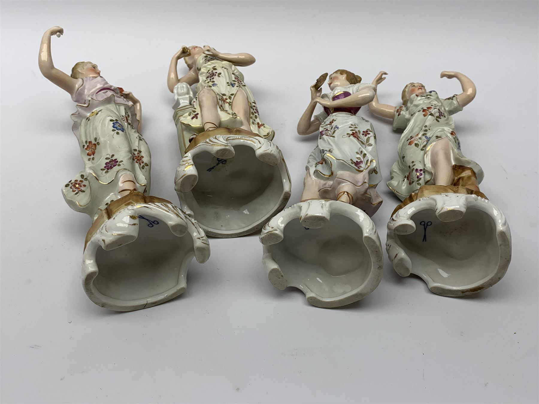 A group of five Continental figurines modelled as the arts, emblematic of music, painting, sculpture, literature, and theatre, each with spurious blue cross mark beneath, H22.5cm. (5). 