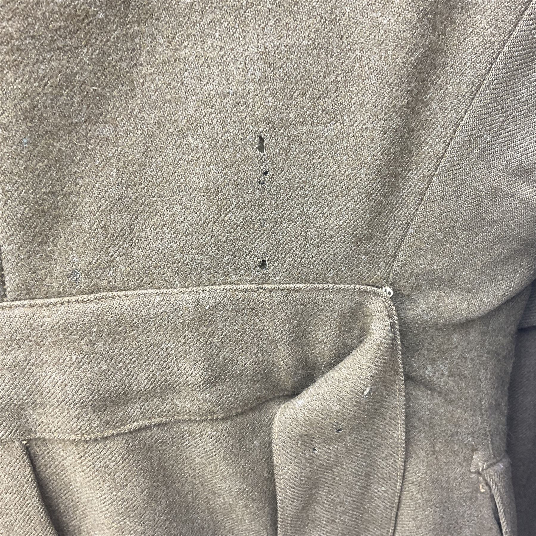 WW2 British female ATS Sergeant's service uniform grouping, consisting of four pocket female pattern service dress tunic with brass ATS shoulder titles and general service buttons; cloth lined interior with the original printed size label dated 1942; the matching khaki service dress skirt; and Greatcoat with size label dated 1945; together with army knitted sleeveless V-neck jumper; WRAC tunic, skirt and overcoat; full length cream and gold thread military evening dress by Hilliers Couture; and four webbing belts