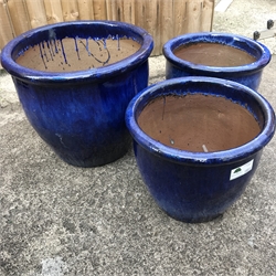 Three large graduating blue glazed terracotta pots, 50cm (max)