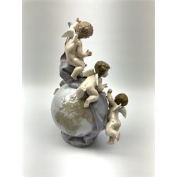 A Lladro mantel clock modelled as a globe with inset clock, surmounted by four putti and floral garlands, with blue printed mark and impressed 5973 beneath, H29cm.