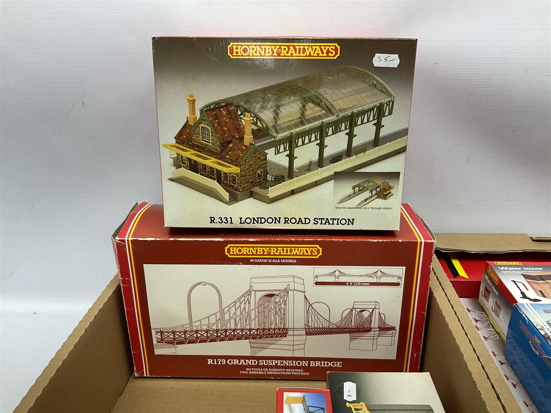 Hornby '00' gauge - nineteen construction kits for trackside buildings and accessories including Grand Suspension Bridge, London Road Station, River Bridge, Viaduct, Engine Shed, Railway Cottages, Water Towers, Girder bridge, Houses, Bell Inn etc; all boxed (19)