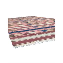 Kilim muted pink ground runner, decorated with rows of horizontal bands in muted tones, alternating with geometric triangular patterns along each band, fringed ends