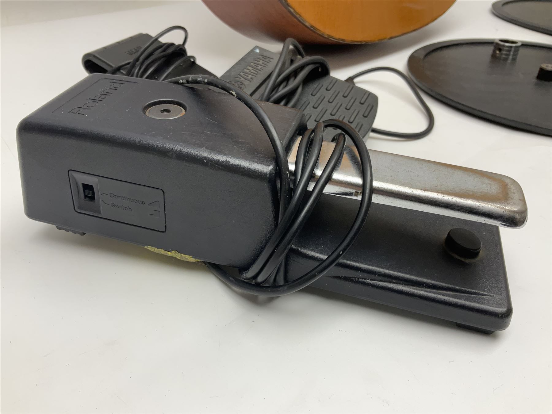 Spanish BM acoustic guitar with mahogany back and sides and spruce top L101cm; in cello carrying case; Roland foot pedal and two Yamaha foot pedals; tin D# organ pipe; folding music stand etc