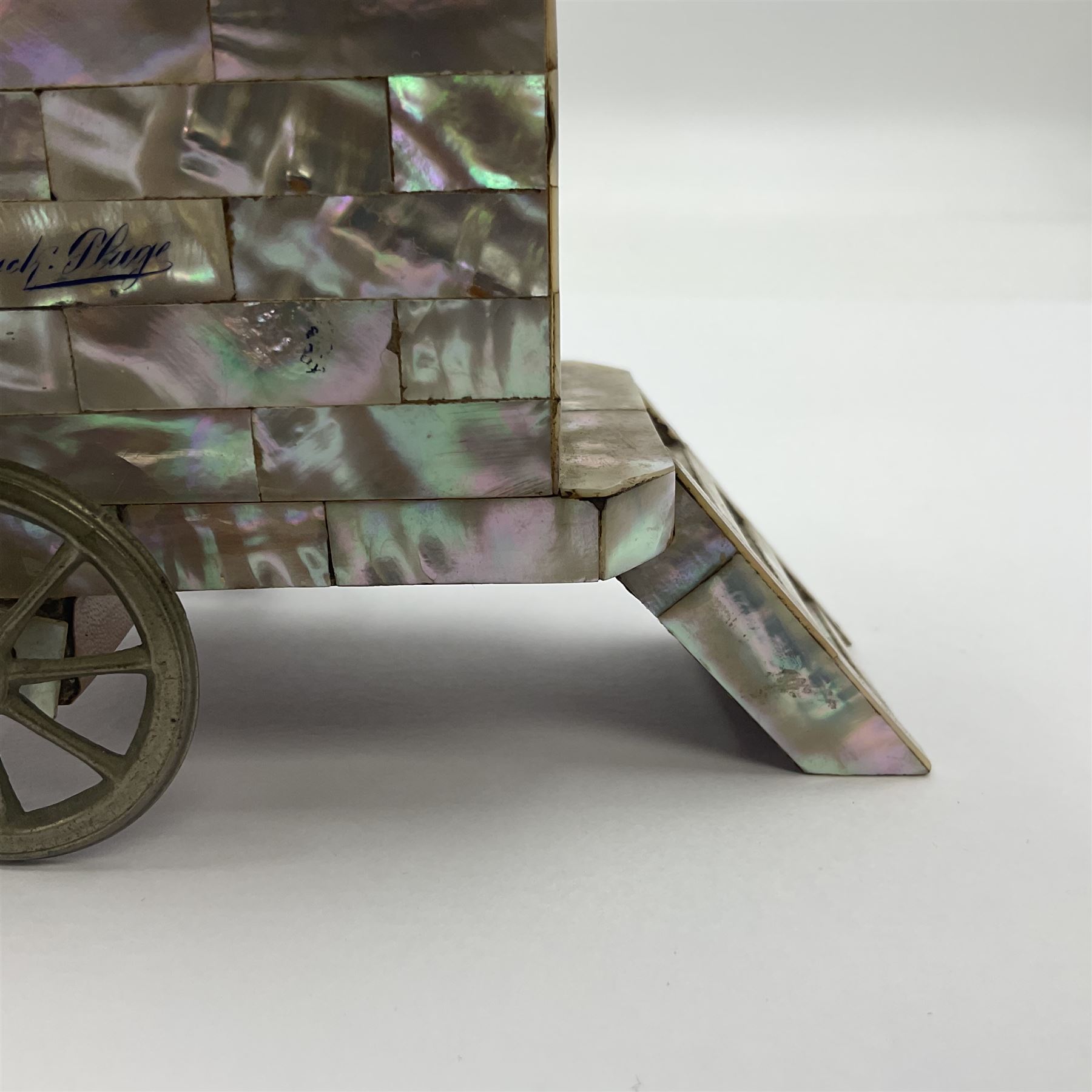 19th century French souvenir jewellery casket in the form of a bathing machine, having mother of pearl panelled tiled effect body, hinged roof/cover revealing a blue silk fitted interior with cushioned base, two silvered metal wheels, abalone shell door and mother of pearl steps, inscribed 'Berck Plage' in blue, H12cm, W13cm 