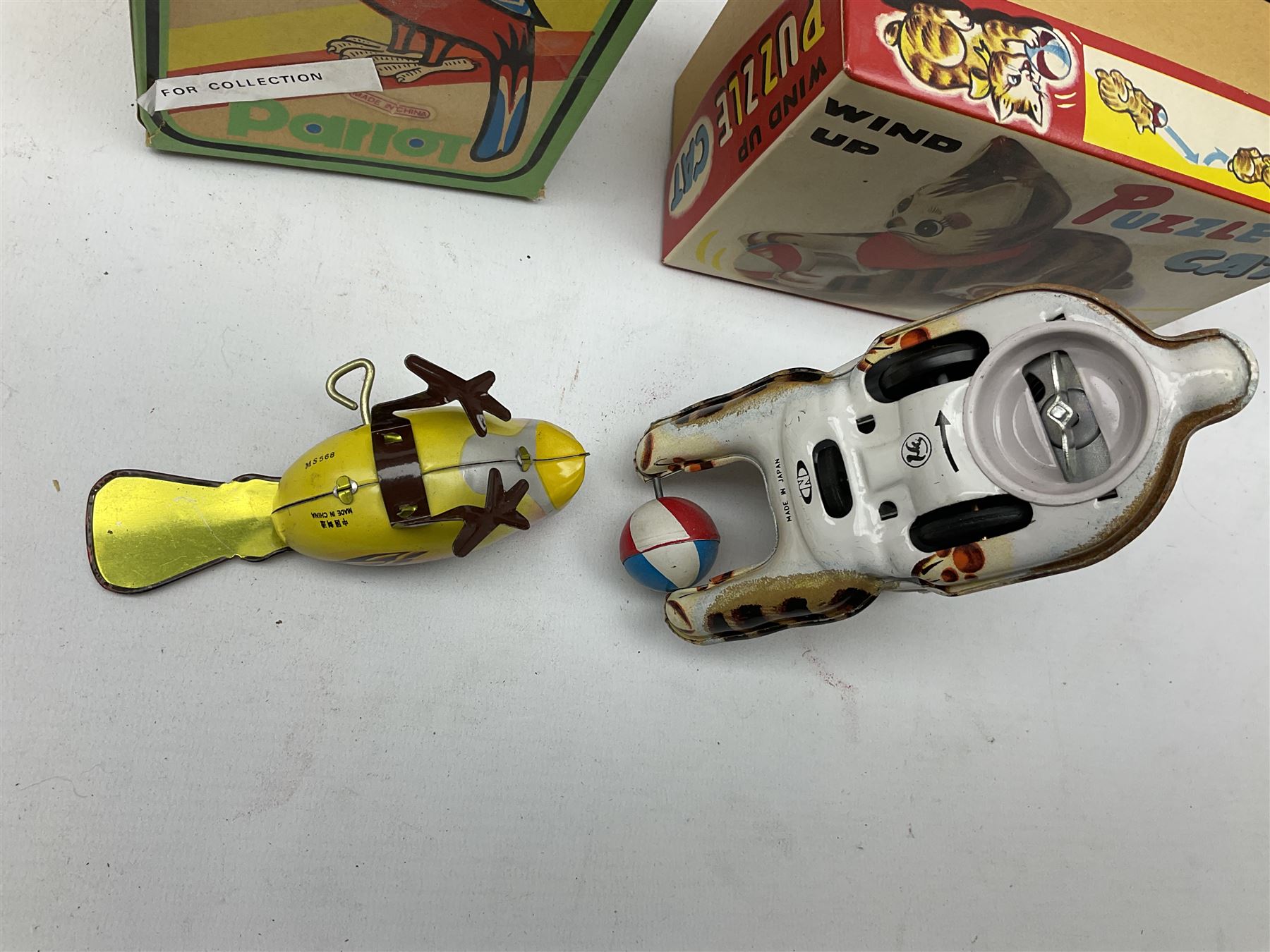 Seven modern Chinese, Japanese and Continental boxed tin-plate toys including Ucan Daire Flying Saucer, Drumming Animal, Circus Clown, Puzzle Cat, Bird with Jumping Action etc; and a quantity of clockwork toy keys (7)