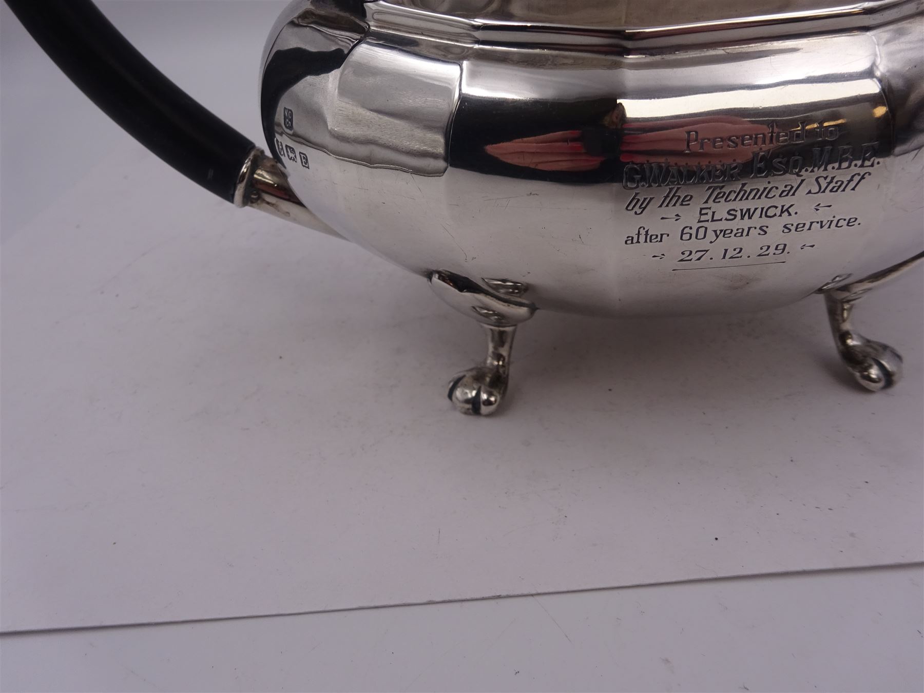 1920s silver teapot, of oval faceted form, with Bakelite type handle and finial, with presentation engraving to body, and upon four paw feet, hallmarked Northern Goldsmiths Co, Birmingham 1929, H16cm