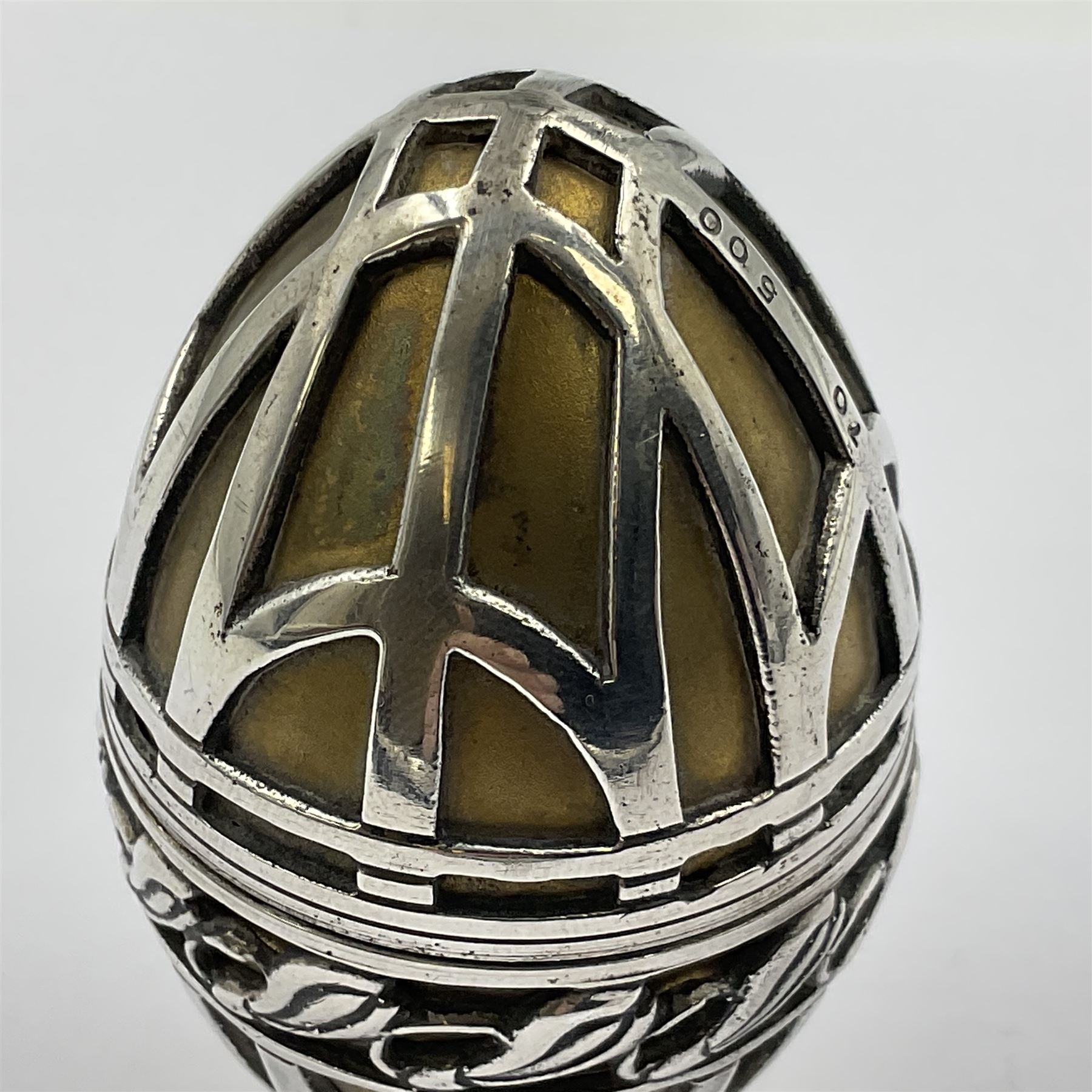 Modern silver limited edition Easter egg, no. 70/500, the gilded body decorated in relief with silver latticework and a band of flower heads, the detachable cover opening to reveal a gilt interior, each hallmarked St James House Company, London 1978, H5.5cm